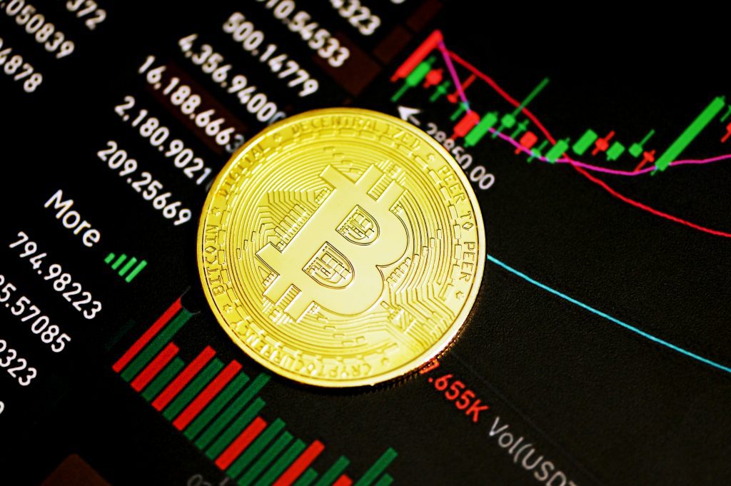 Bitcoin Münze vor einem steigenden Bitcoin Kurs