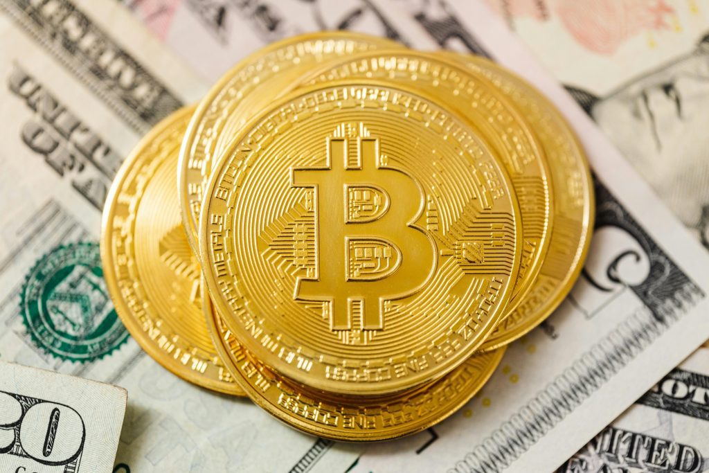 Bitcoin Münzen liegen auf US-Dollar-Scheinen