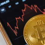 Bitcoin Kurs fällt auf Smartphone mit BTC Münze davor